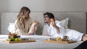 A couple in a hotel room with a bed, breakfast tray, and a coffee cup. - Hôtel Hélios Opéra (Paris)
