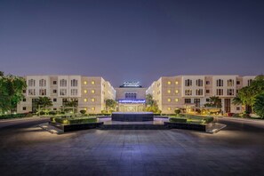 A modern hotel with a symmetrical facade, a central entrance, and well-lit surroundings. - Le Meridien Medina (Madinah)