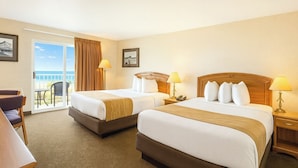 A hotel room with two beds, a balcony with a view, and a desk with a chair. - Bridge Vista Beach - Hotel & Convention Center (Mackinaw City)