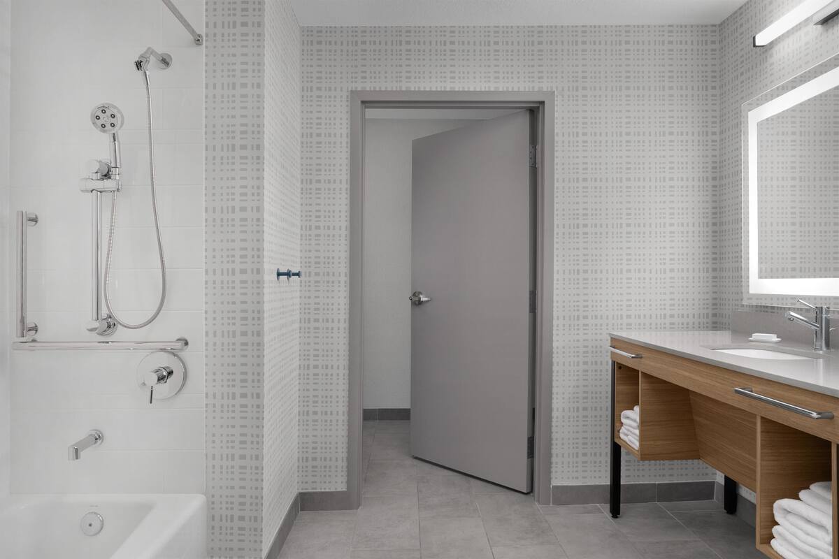 A modern bathroom with a shower, toilet, and sink.