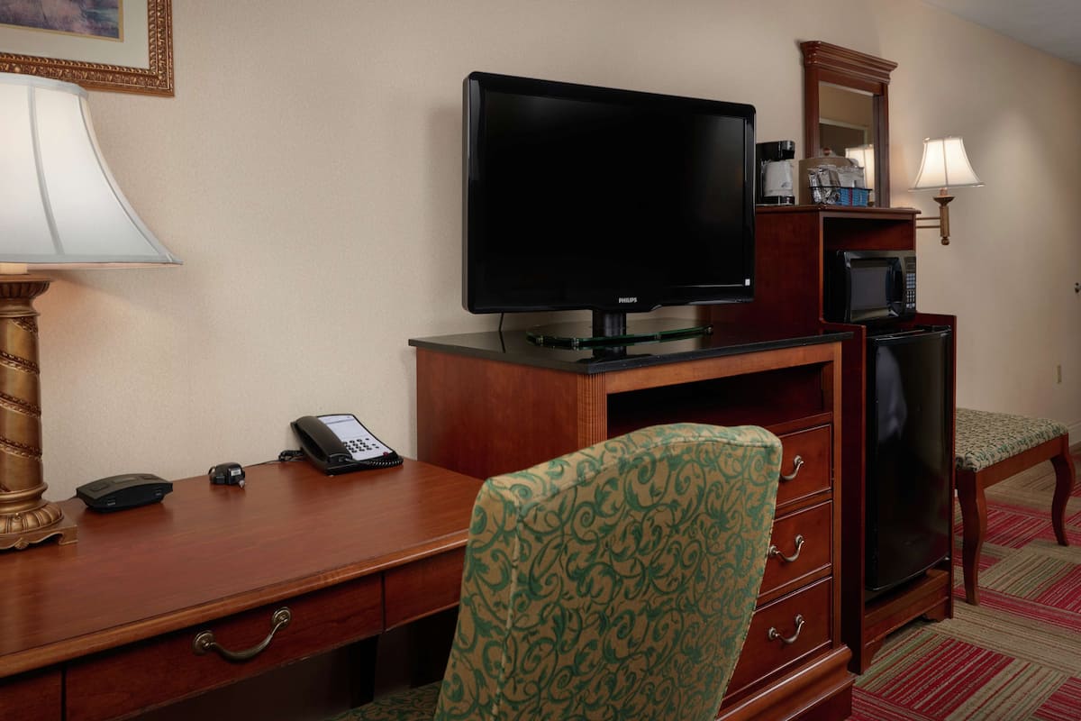Escritorio, cortinas blackout y tabla de planchar con plancha