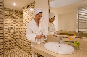 A modern bathroom with a shower, a sink, and a mirror.