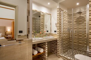 Et moderne badeværelse med to håndvaske, en glasbrusekabine og et toilet.