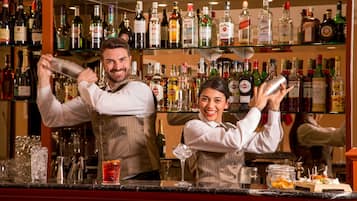 A bar area with shelves of liquor bottles and a bartender preparing drinks.