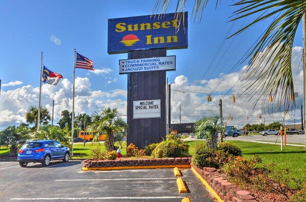 A Sunset Inn sign with amenities listed including truck parking, commercial rates, and Jacuzzi suites.