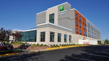 A Holiday Inn Express building with a modern architectural design, featuring large windows and a mix of grey and orange facades.