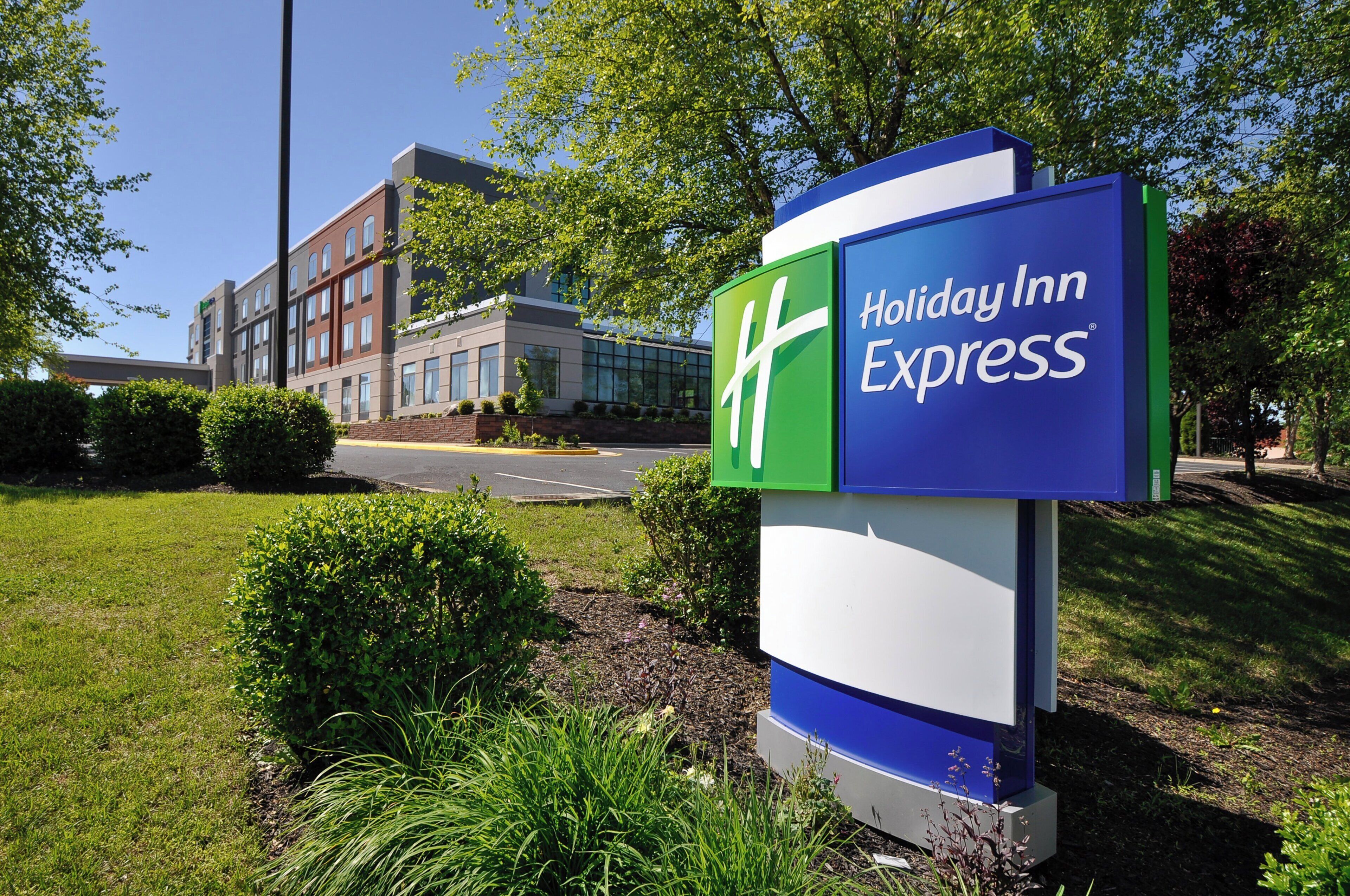 A Holiday Inn Express sign with a modern building in the background.