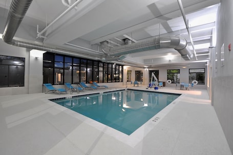 Una piscina techada, sillones reclinables de piscina