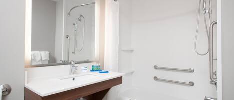 A modern bathroom with a white sink, mirror, and shower.