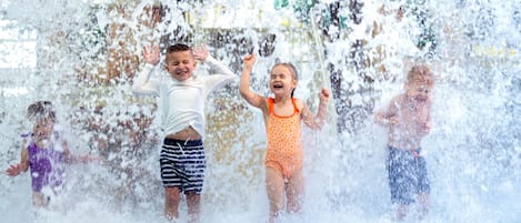 Children playing in a water play area with a blue surface.