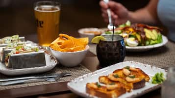 A dining table with various dishes, including tacos, a salad, and toast with avocado.