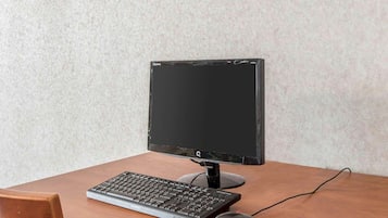 Un escritorio de madera con un monitor negro, teclado y ratón.