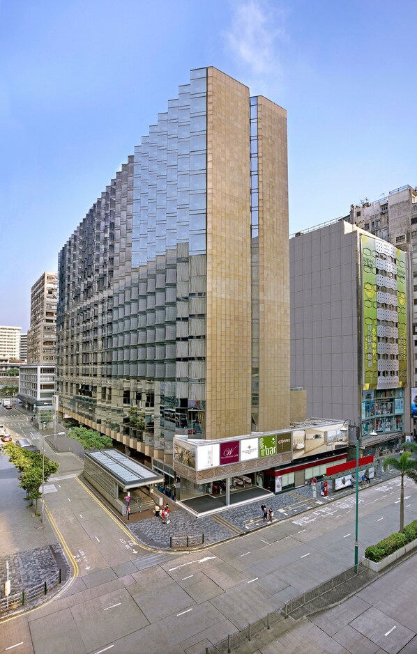 A modern high-rise building with a glass facade and a prominent vertical section. - The Kowloon Hotel (Kowloon)