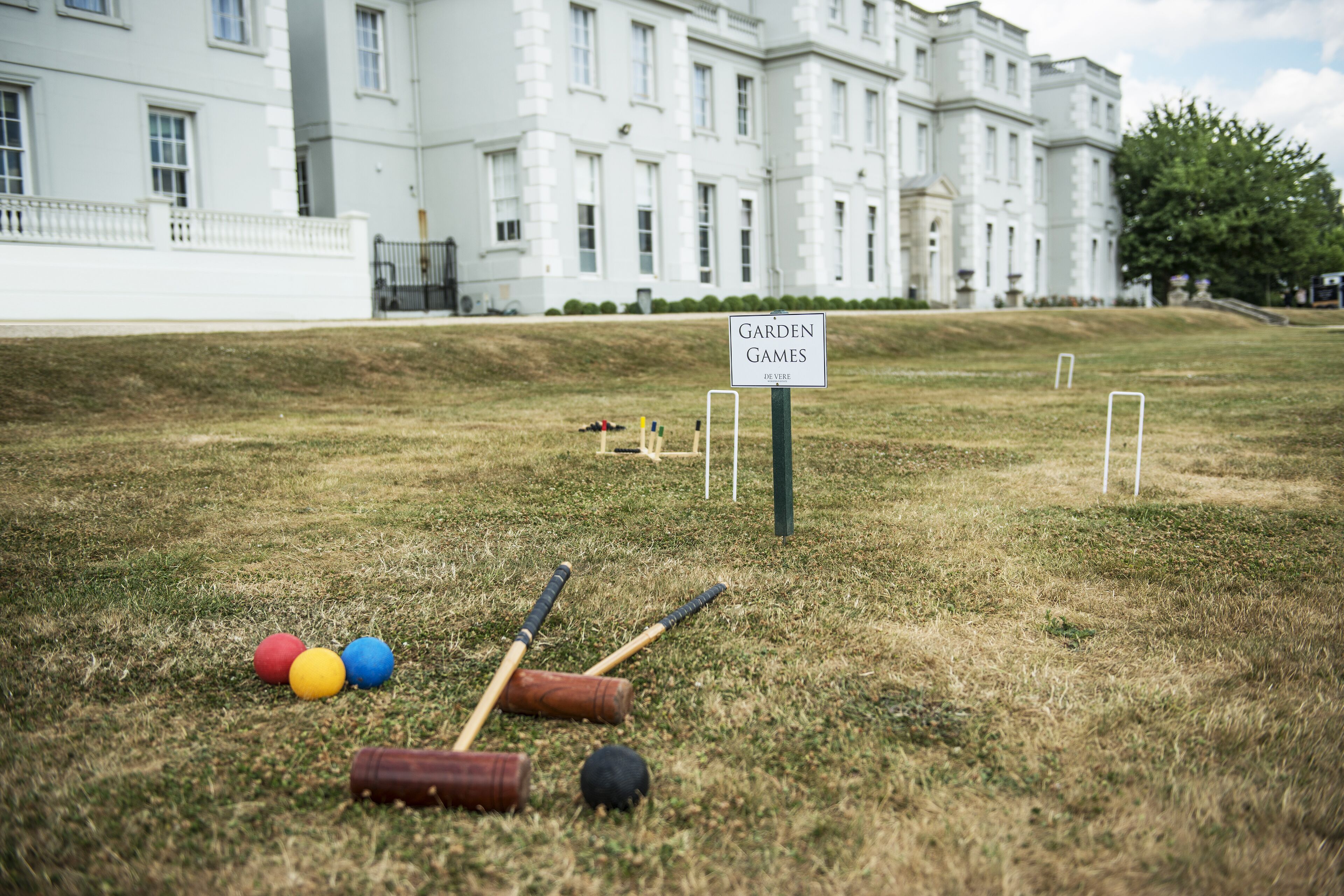 Césped con equipo de croquet y un cartel que dice 'Garden Games'.