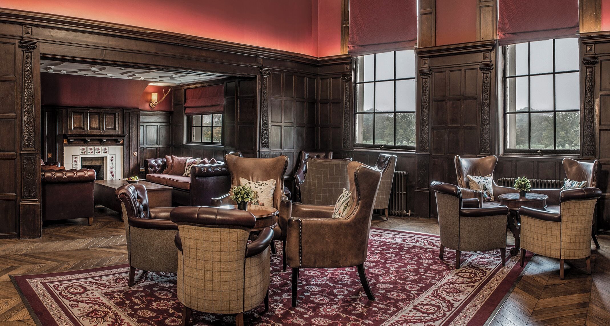 A traditional room with a fireplace, leather armchairs, and a patterned rug.