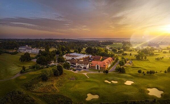 A golf course with a clubhouse and residential buildings.