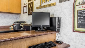 A hotel reception desk with a computer, keyboard, and mouse. - Rodeway Inn Elko Downtown Area (Elko)