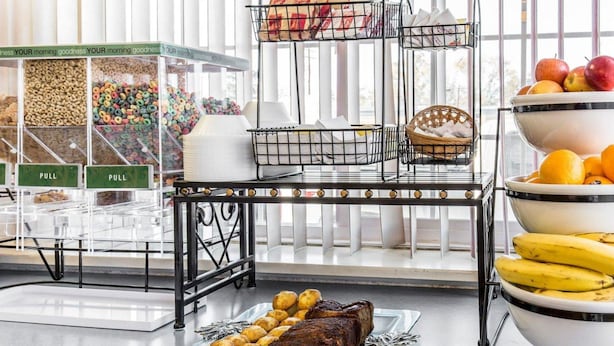 A buffet setup with various food items, including fruits, vegetables, and a roasted meat dish. - Rodeway Inn Elko Downtown Area (Elko)
