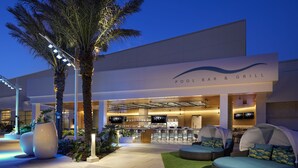 A pool bar and grill with outdoor seating and a modern architectural design.