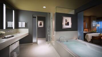 A modern bathroom with a bathtub, a large mirror, and a vanity with a sink.