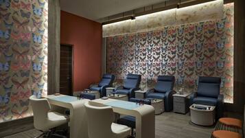 A room with a long table, four chairs, a mirror, and a wall with butterfly patterns.