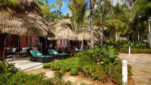 A resort with thatched-roof structures, lounge areas with cushions, and tropical vegetation. - Seminole Hard Rock Hotel and Casino (Hollywood)