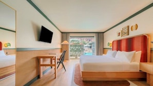 Ein Hotelzimmer mit Bett, Schreibtisch, Stuhl, Fernseher und einem Fenster mit Blick.