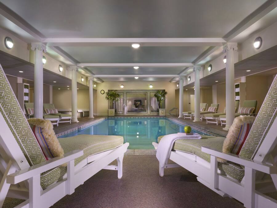A pool area with lounge chairs and a pool.