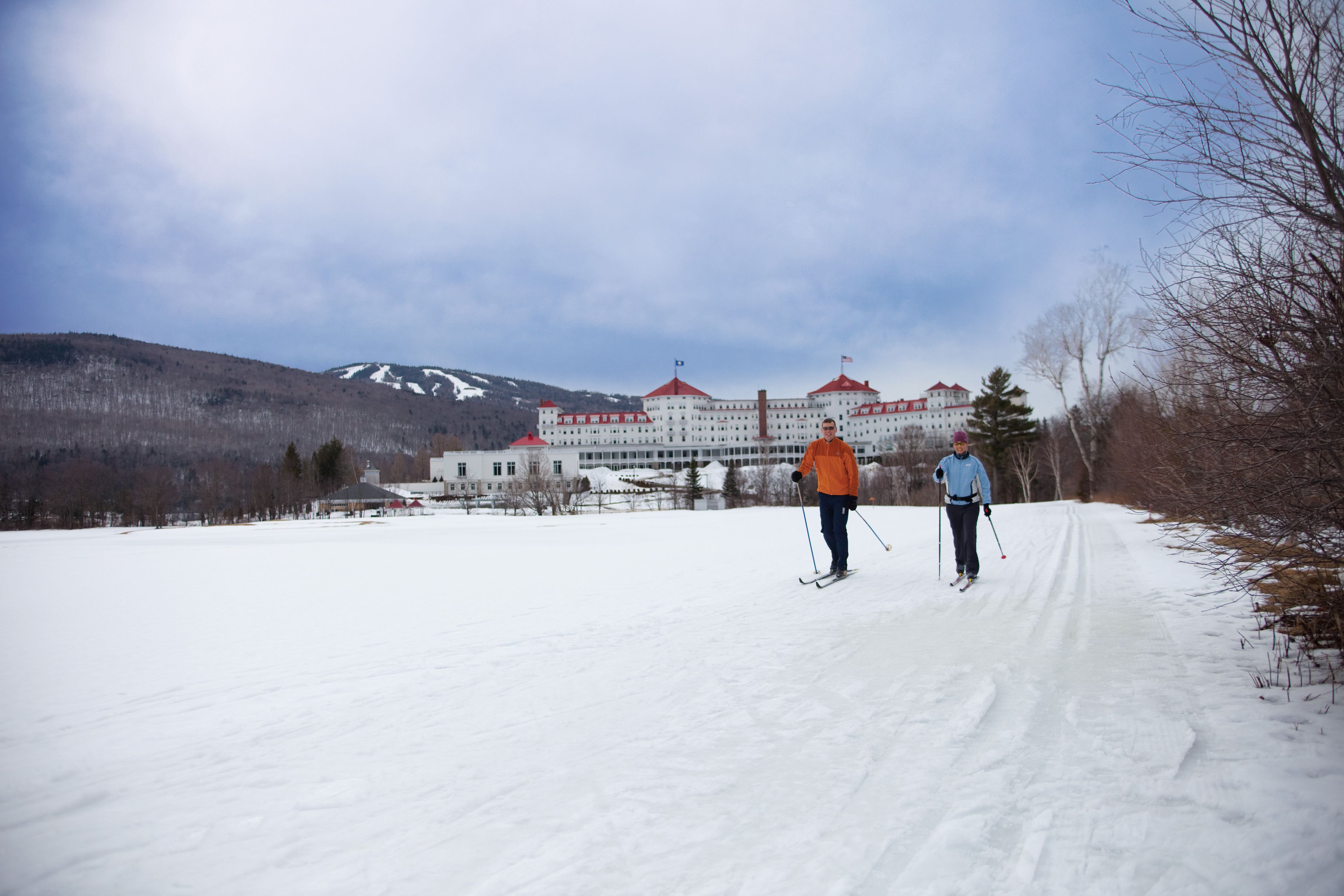 Un paisaje cubierto de nieve con un edificio grande al fondo.