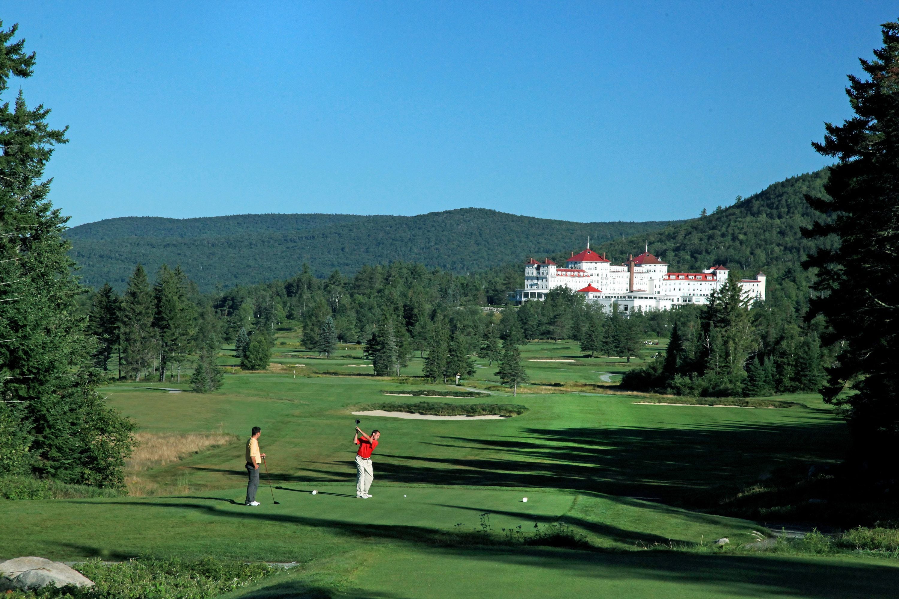 A golf course with a large building in the background.