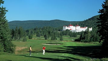 A golf course with a large building in the background.