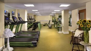 A gym with treadmills, exercise balls, and a chair with a vase of sunflowers. - Omni Bretton Arms Inn at Mount Washington (Bretton Woods)