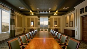 A conference room with a long table, chairs, and a view of mountains through large windows. - Omni Bretton Arms Inn at Mount Washington (Bretton Woods)