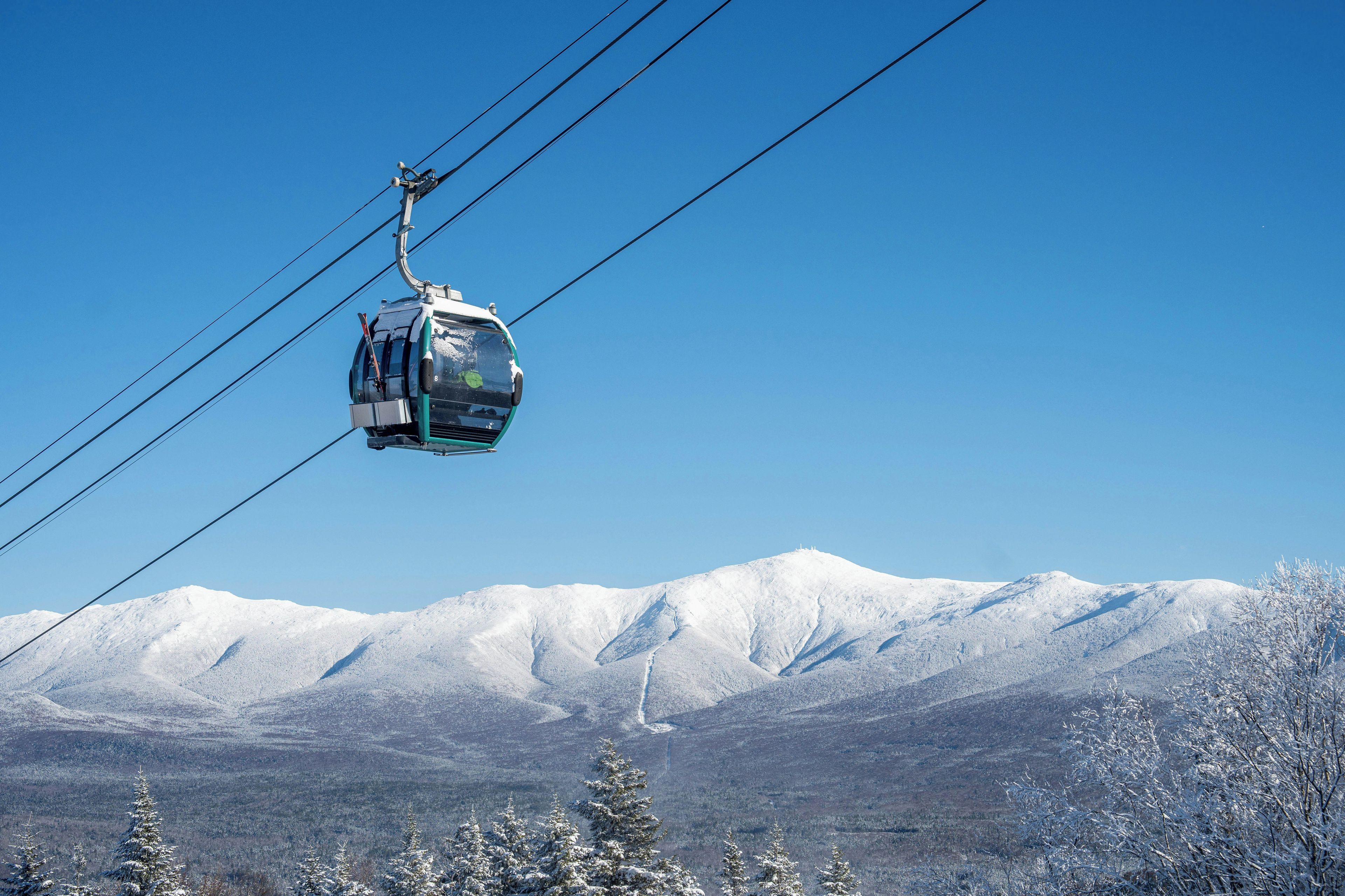 Eine Standseilbahn über einer verschneiten Berglandschaft.
