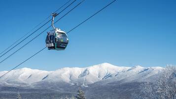 A cable car suspended over a snowy mountain landscape.
