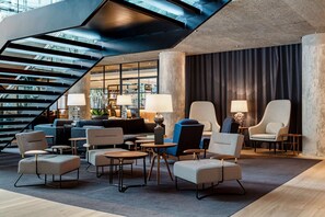 Relax in our spacious seating area with armchairs and sofas, surrounded by a large window offering a view of the interior.
