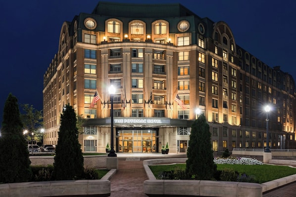 A large, multi-story hotel with a classic architectural style, featuring a prominent entrance and a well-lit facade.