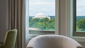 A room with a large window, a chair, and a table.
