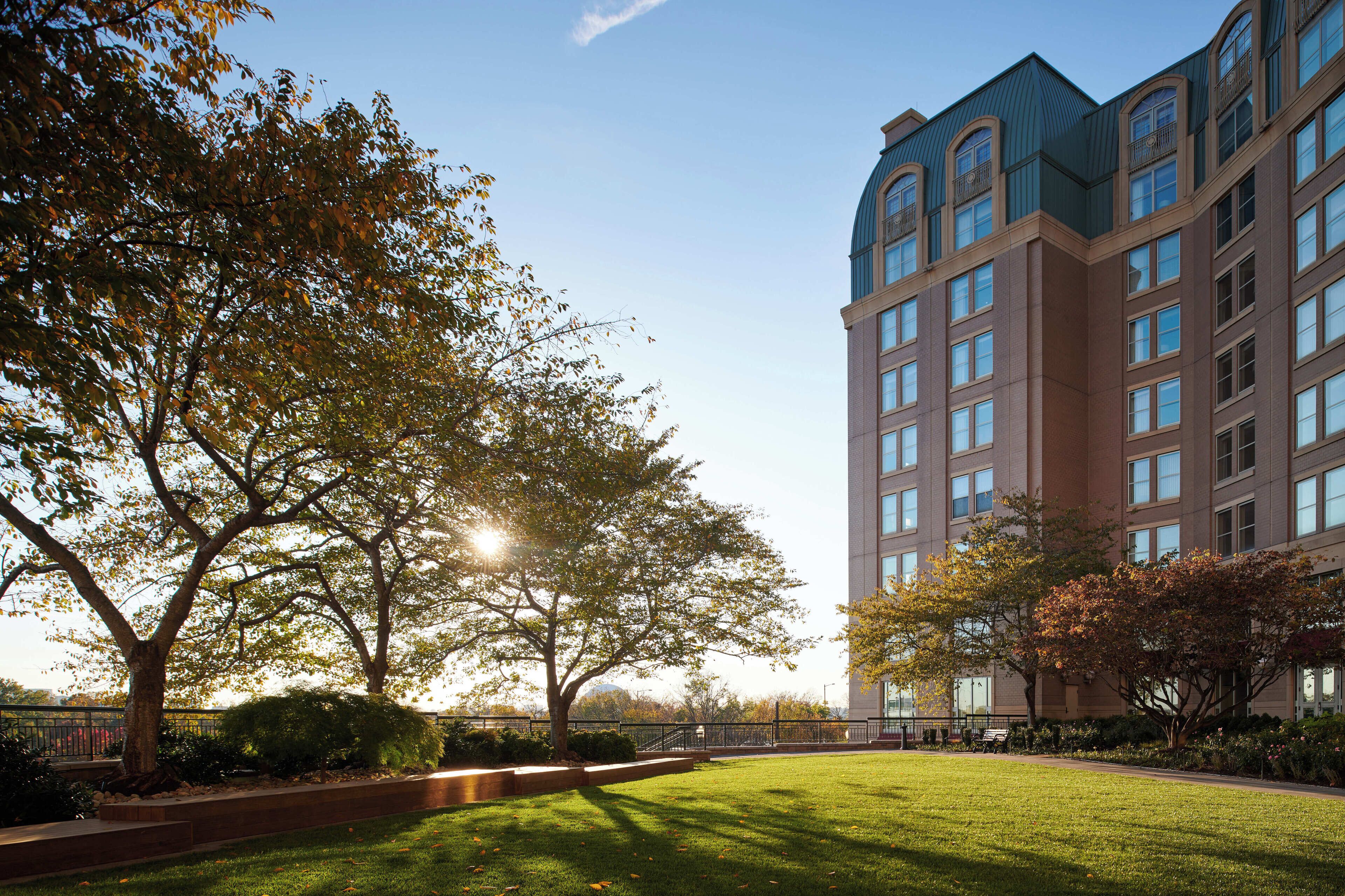 A multi-story building with a modern architectural design, surrounded by well-maintained lawns and trees.