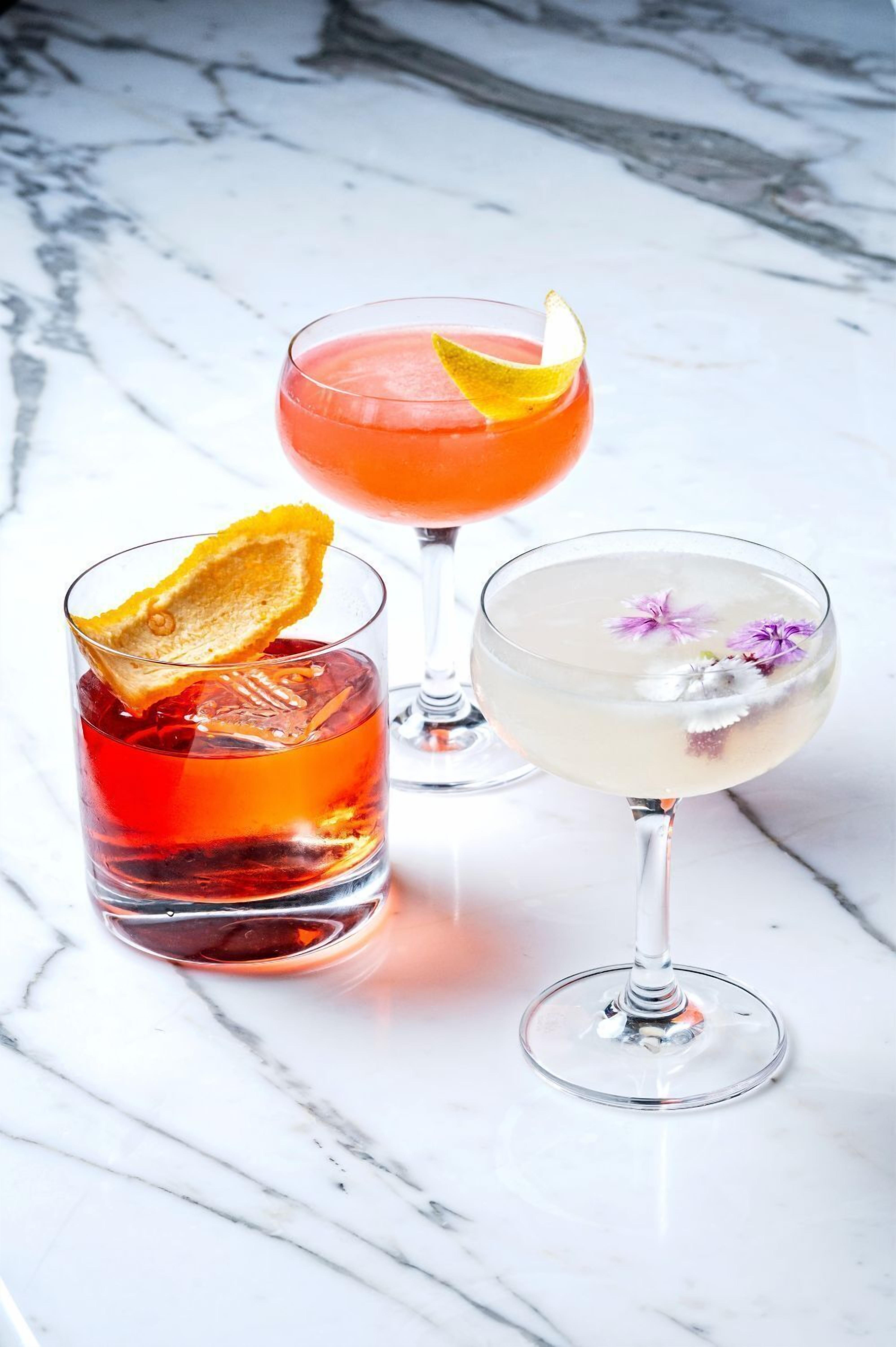 Drei Cocktailgläser auf einer Marmorplatte.