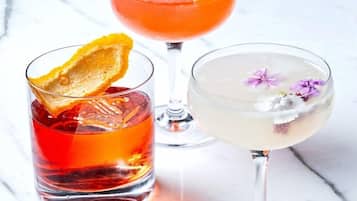 Drei Cocktailgläser auf einer Marmorplatte.