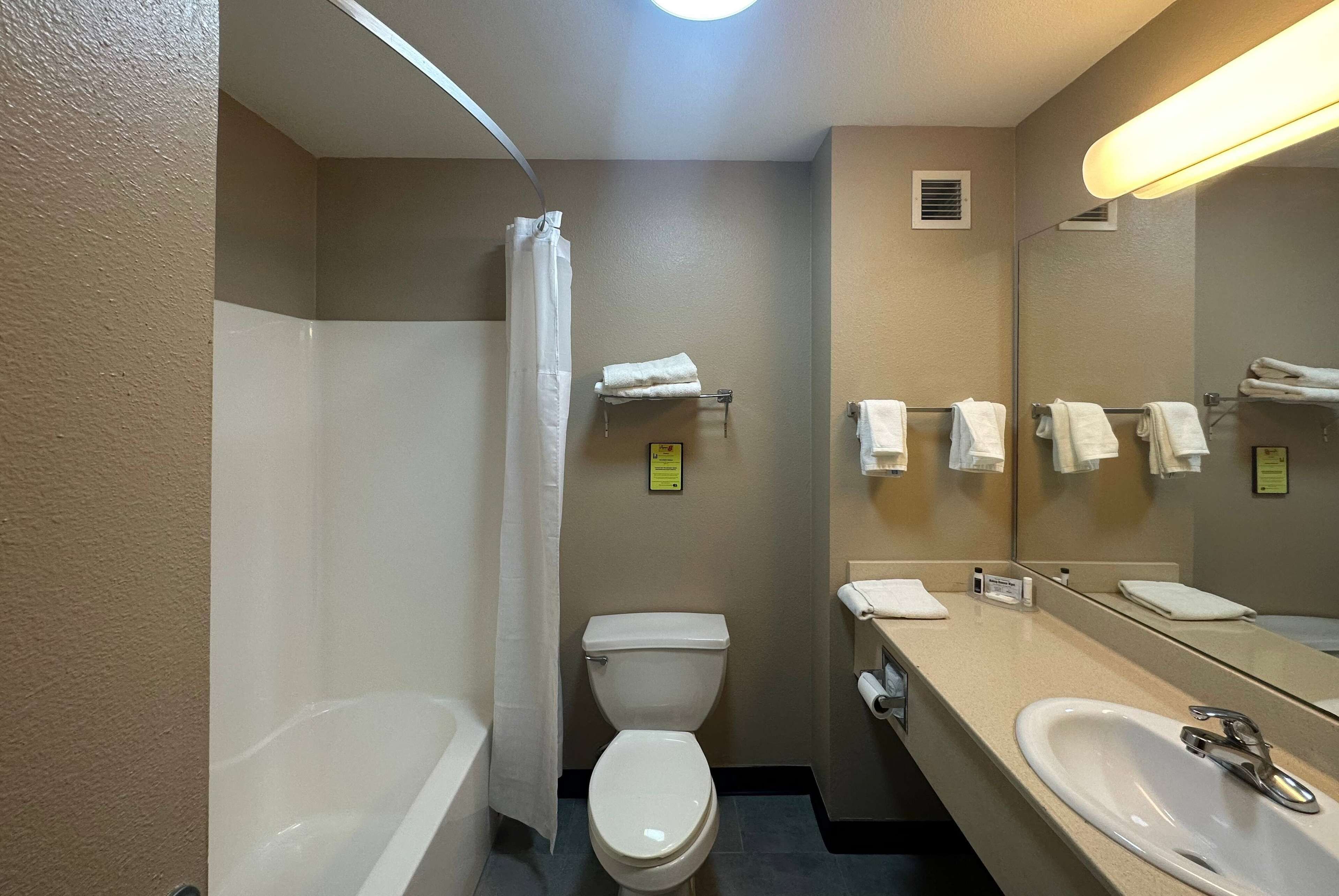 Un baño con bañera, inodoro, lavabo y espejo.