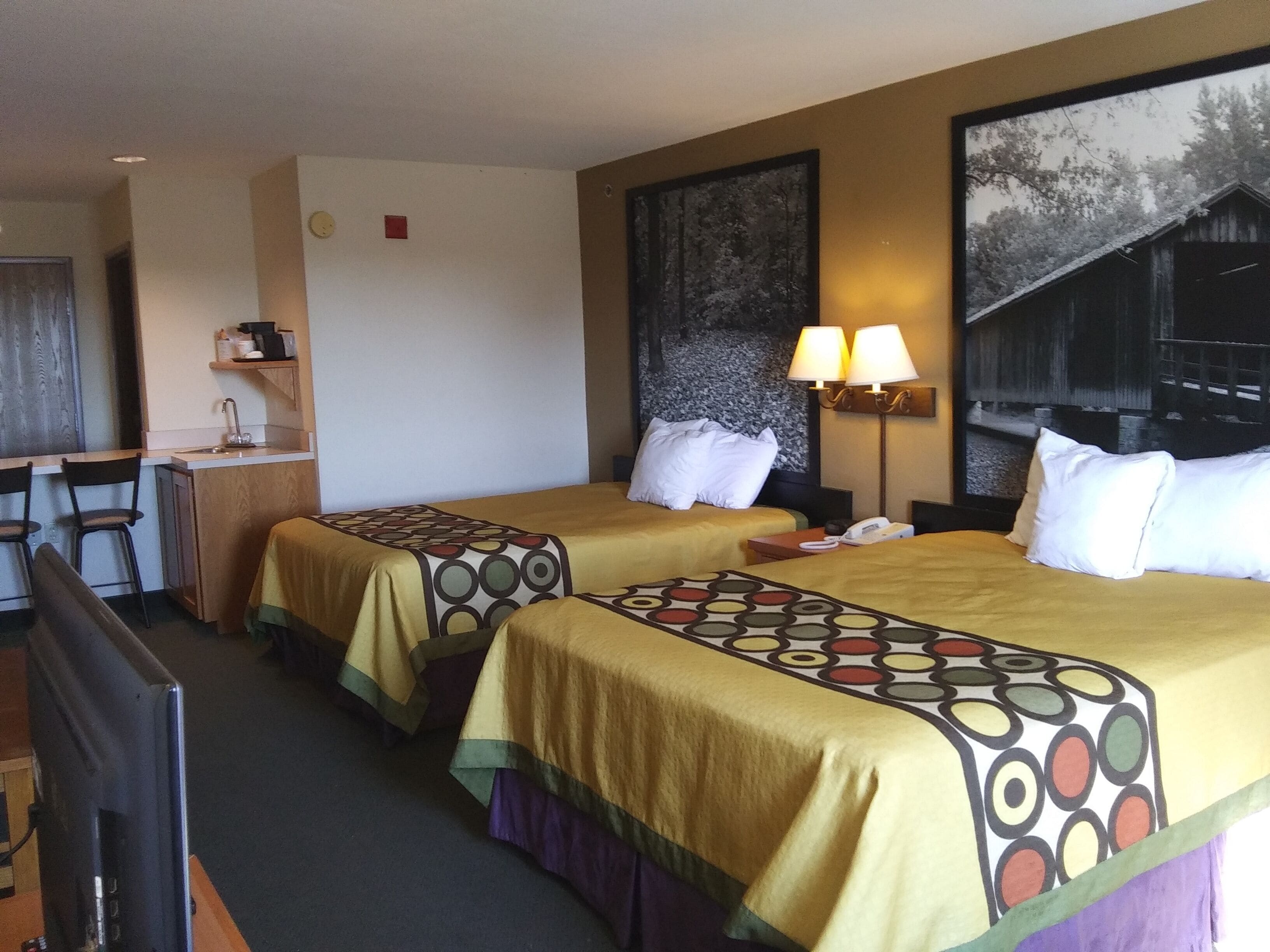 Ein Hotelzimmer mit zwei Betten, einem Schreibtisch und einem Stuhl.