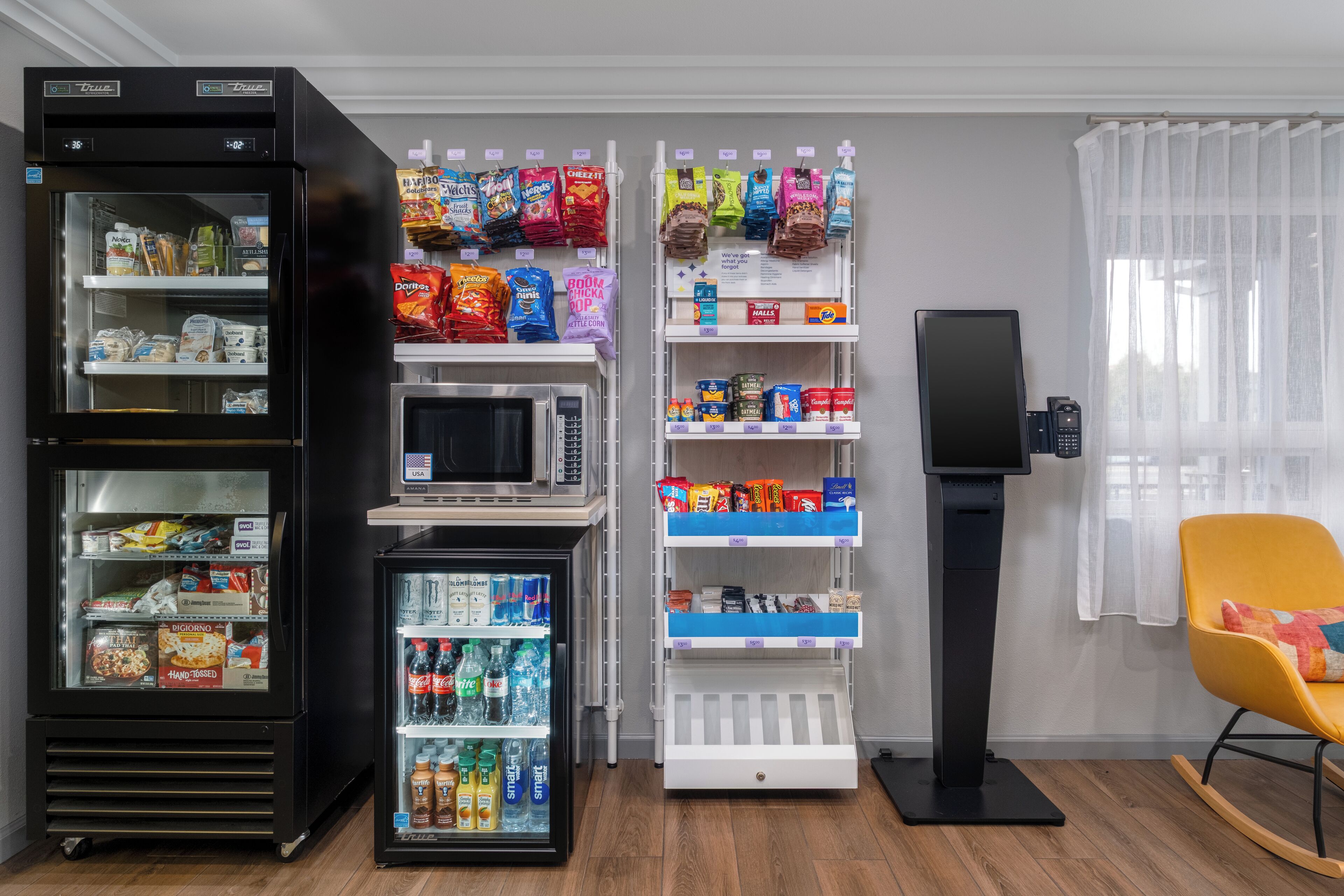 A self-service kiosk with snacks and beverages, a microwave, and a speaker.