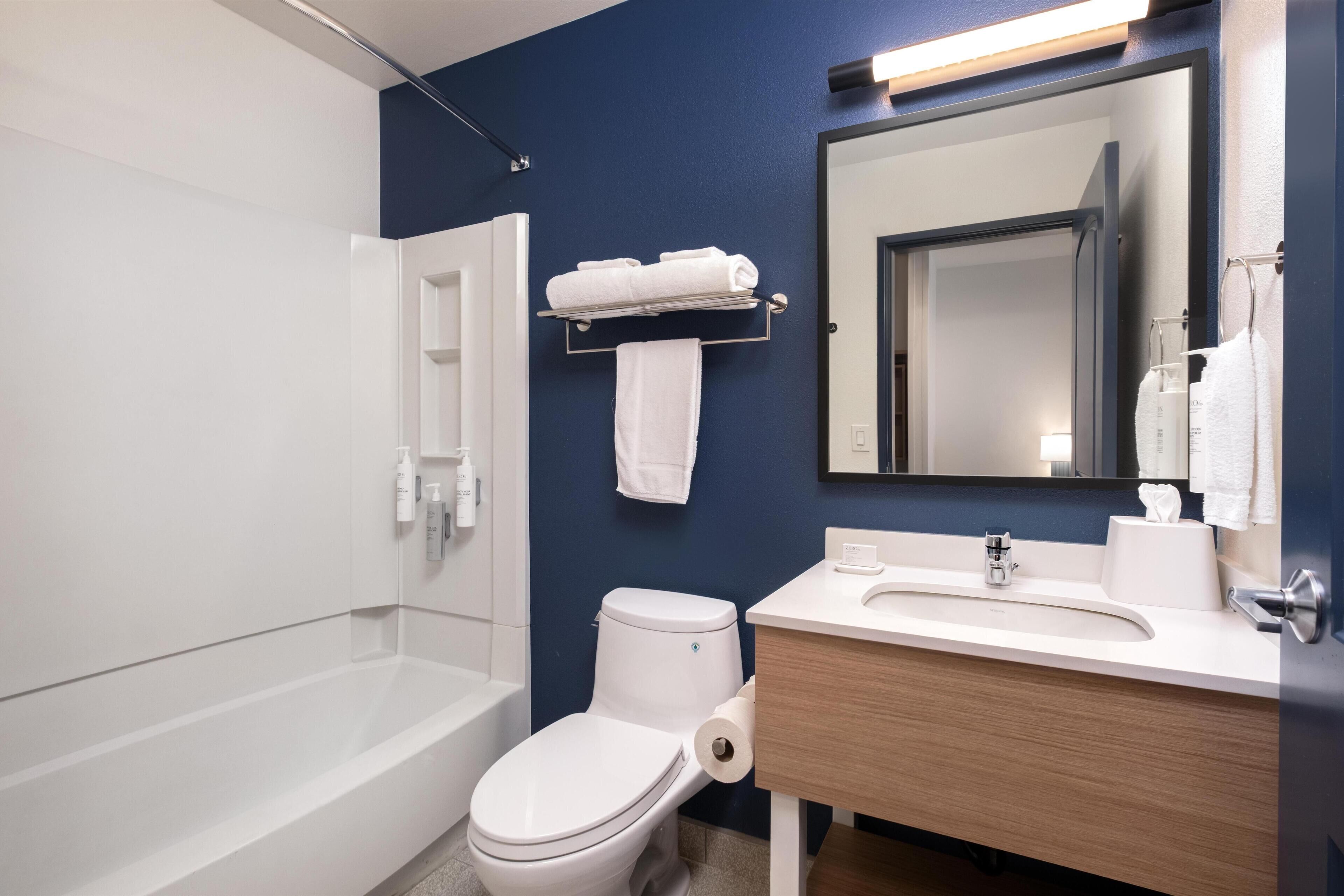 A modern bathroom with a bathtub, toilet, and sink.