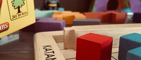A wooden board game with blocks labeled "KATAMINI" and a Batman action figure.