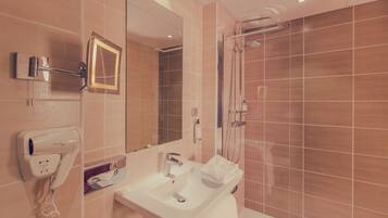 A bathroom with a sink, mirror, hairdryer, and shower.