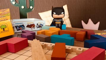 A board game with various colored blocks and a Batman figurine.