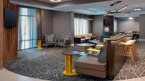 A modern hotel lobby with a curved seating area, a bar, and a television mounted on the wall. - SpringHill Suites by Marriott Portland Hillsboro (Hillsboro)