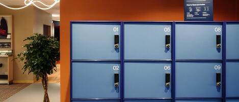 A row of blue lockers numbered 01 to 10, with a sign above detailing locker usage instructions.